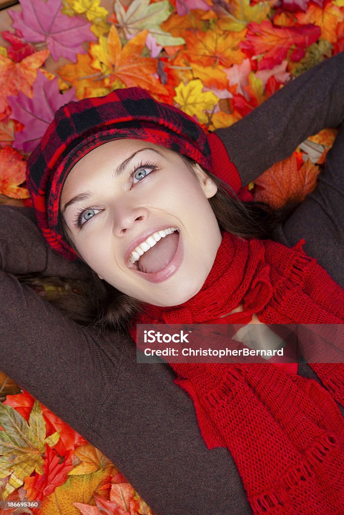 Heureuse jeune femme jeter les feuilles d'automne - Photo de 20-24 ans libre de droits