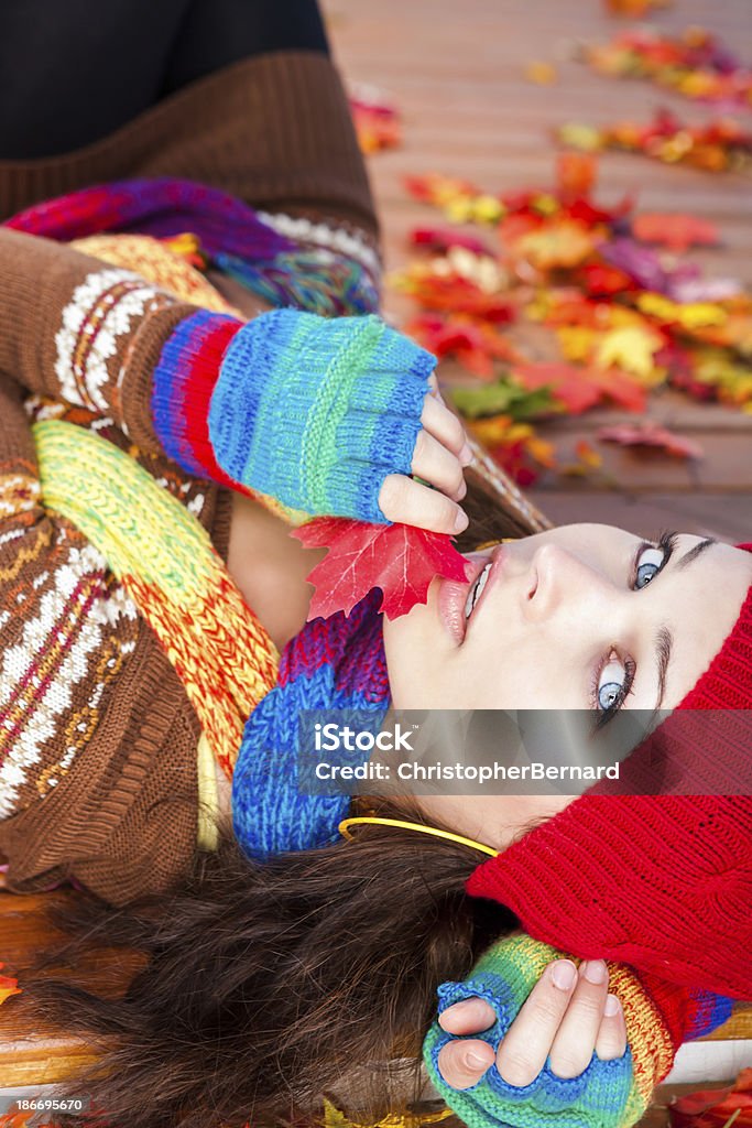 Giovane donna gettando autunno foglie su - Foto stock royalty-free di 20-24 anni