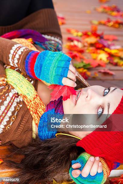 Foto de Jovem Mulher Colocar Em Folhas De Outono e mais fotos de stock de 20-24 Anos - 20-24 Anos, Adulto, Barrete - Chapéu