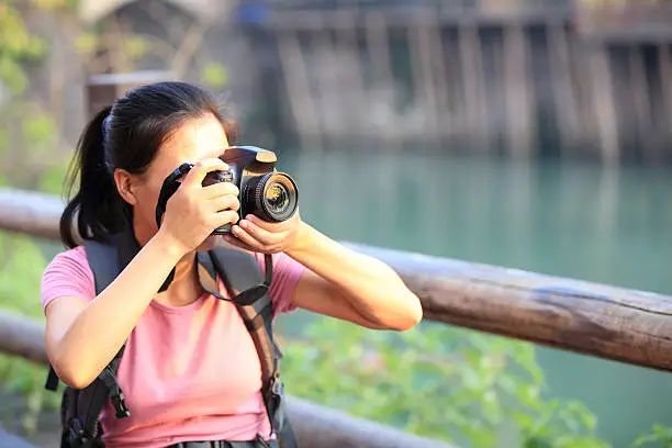 young asian woman tourist taking photo at fenghuang anceint city,hunan province,china