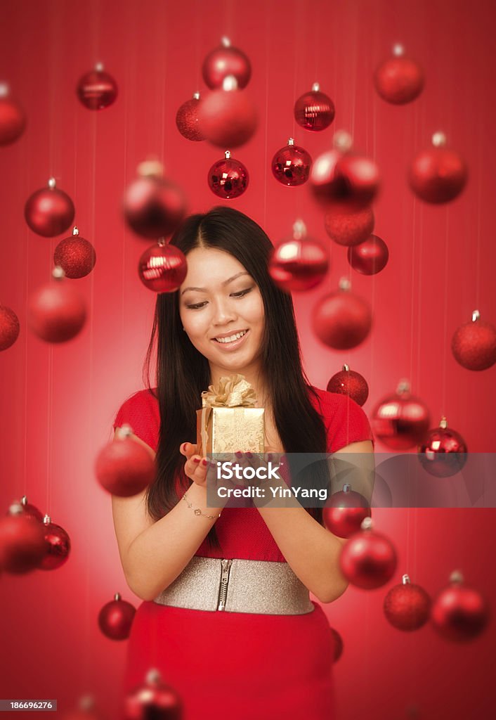 Asiatische Frau Holding Geschenk mit roten Christmas Theme Hintergrund - Lizenzfrei Asiatischer und Indischer Abstammung Stock-Foto