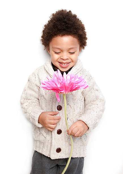 istock Cute child holding big pink flower and looking at it 186696284