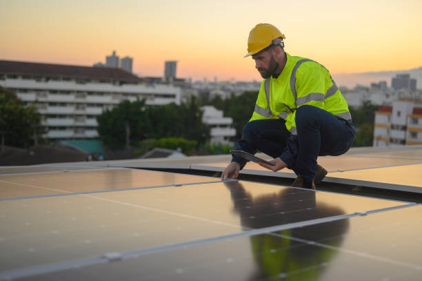 istock Male engineer works installing solar panels on the roof. Engineer or worker working on solar panels or photovoltaic cells on the roof of a business building. 1866966934