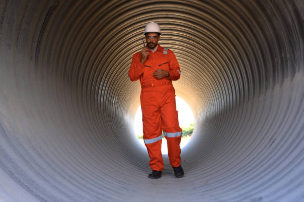 istock Smart engineer with safety suit holding walkie-talkie inspecting large power system pipeline. 1866969005