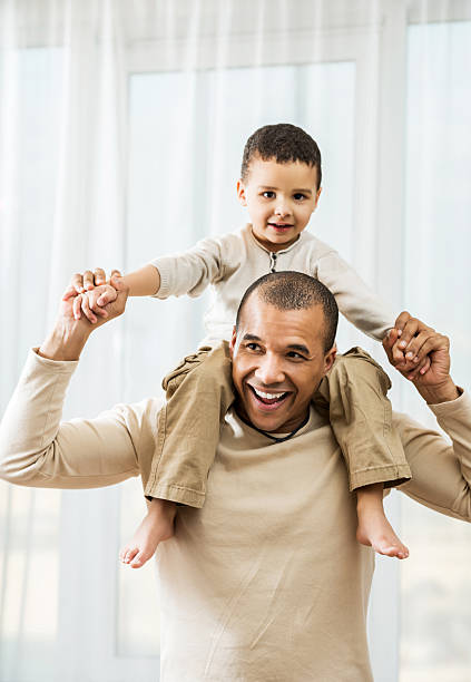 istock African American father carrying his son on shoulders. 186697017