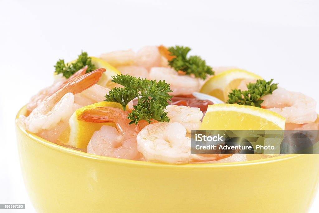 Shrimp Cocktail Appetizer Fresh shrimp served in yellow bowl with cocktail sauce, lemon wedges, and sprigs of green parsley.   Served on a bed of crushed ice.  Captured as a 14-bit Raw file. Edited in 16-bit ProPhoto RGB color space. Appetizer Stock Photo