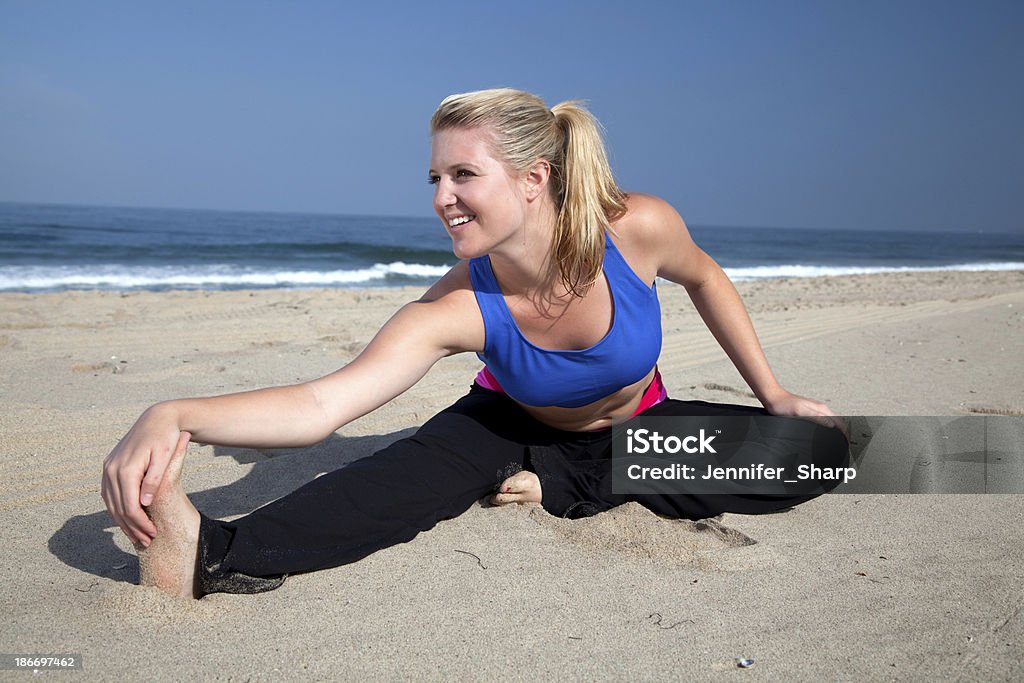 Piękna kobieta o blond włosach bawi ćwiczenia na plaży - Zbiór zdjęć royalty-free (Aktywny tryb życia)