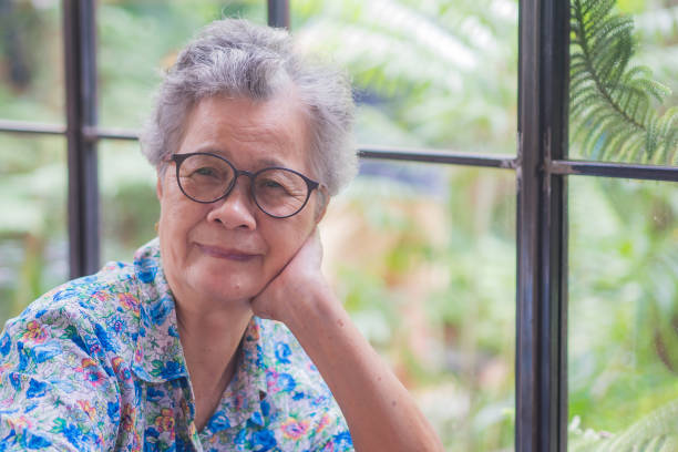 istock Senior woman smiling and looking at camera while sitting at a desk. 1866993853