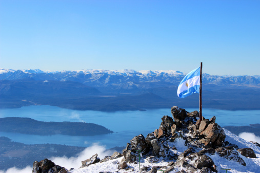 Argentina flag stand at the top of CERRO CATEDRAL MOUNTAIN - in front of Lynch Refuge (Patagonia - Argentina).