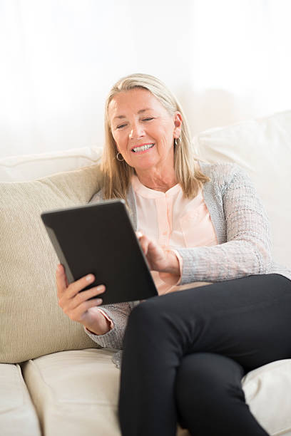 istock Smiling Woman Using Digital Tablet At Home 186699631
