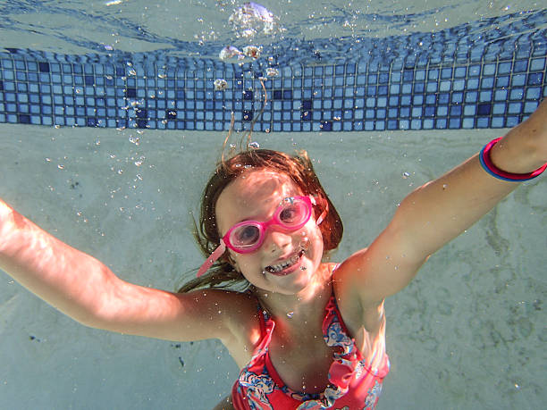 istock Fun little girl playing in a pool with goggles 186700050