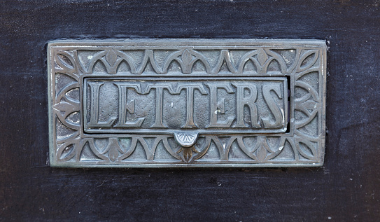 Letterbox on the black wall. Retro style, aged metal plate