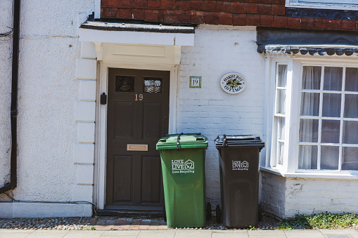 Rye, England - June 13, 2023: Wheelie bins on the pavement waiting for rubbish collection, UK.