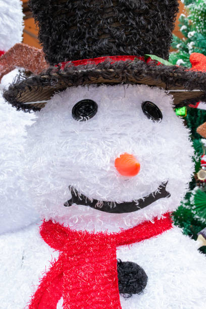 istock snowmans head nearby fir-tree at vertical composition 1867011219