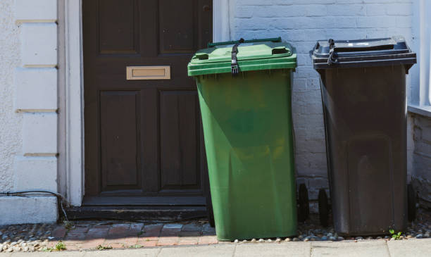 Wheelie Bins Wheelie bins on the pavement waiting for rubbish collection, UK. overflowing trash dumpster stock pictures, royalty-free photos & images