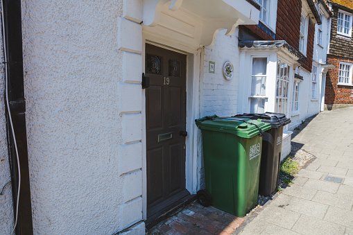 Rye, England - June 13, 2023: Wheelie bins on the pavement waiting for rubbish collection, UK.