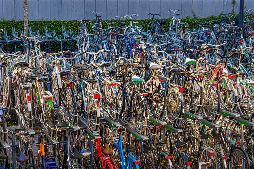 Large public bicycles parking. Old colorful bicycles in a parking lot. Parking with many bicycles on one of the central streets of Netherlands, Germany or any other european big city