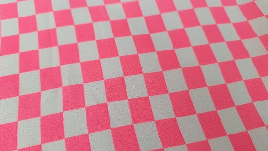 The background is a pink and white checkered painting motif on a woman's dress.