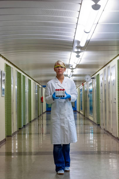 istock Scientist holding test tube rack walking in hallway 1867027630
