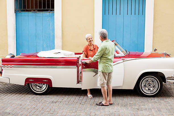 senior pareja llegar en automóvil - collectors car mature men transportation lifestyles fotografías e imágenes de stock