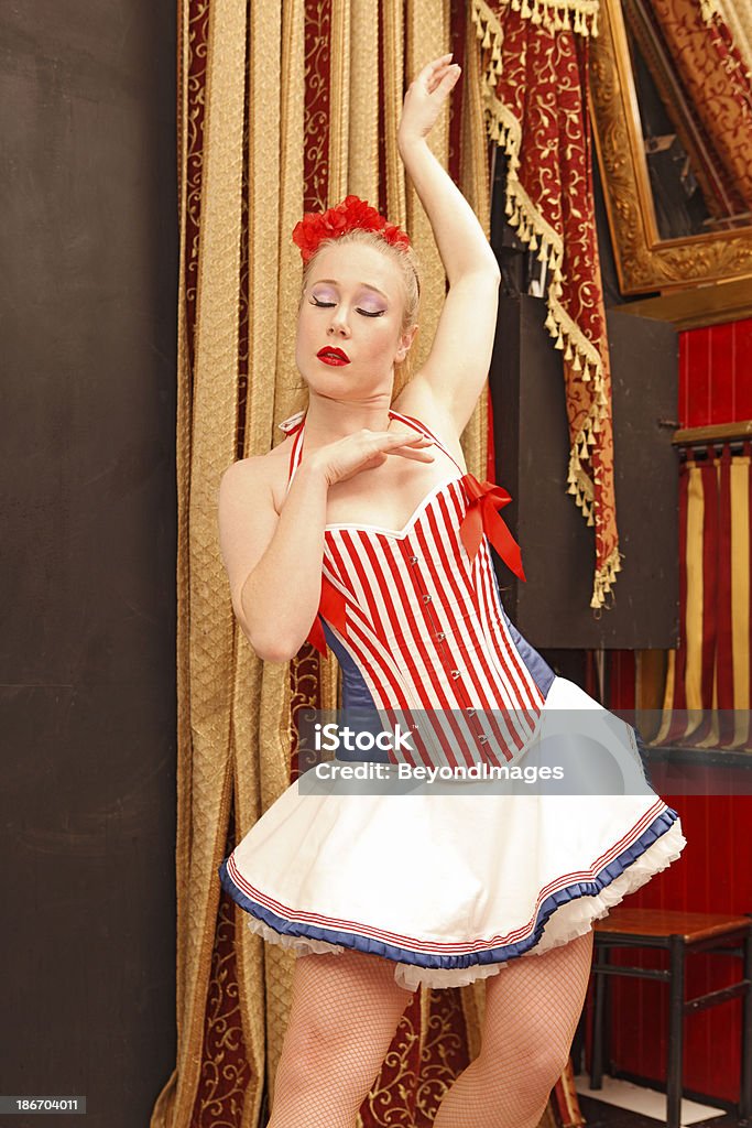 Blonde exotic dancer posing with curtains Blonde exotic dancer posing in front of plush curtains.  Her eyes are closed. Adult Stock Photo