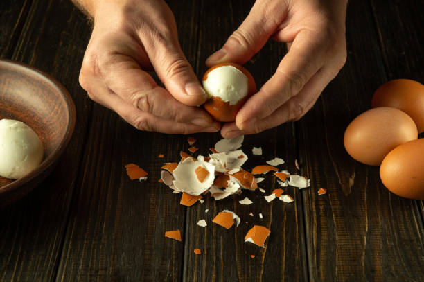 istock Chef hands peel boiled eggs for preparing a national dish on the kitchen table. Healthy egg diet concept 1867043722