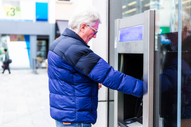istock Senior man withdrawing cash from ATM machine 1867044241