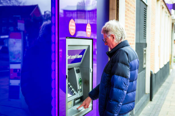 istock Senior man withdrawing cash from ATM machine 1867045290