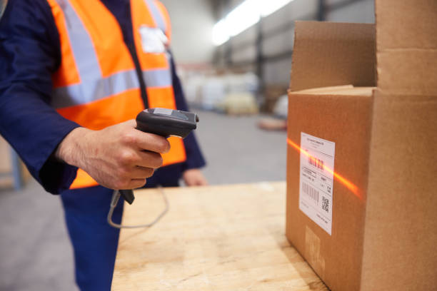 operatore che scansiona scatole con un lettore di codici a barre in un magazzino - warehouse bar code reader manual worker working foto e immagini stock