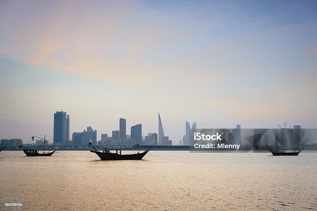 Bahrain Manama,Modern Skyline and Traditional Dhows Skyline of Manama with dhows, the traditional ships, in front of the skyscrapers. Sunset in Manama, Bahrain, Middle East. Famous Place Stock Photo