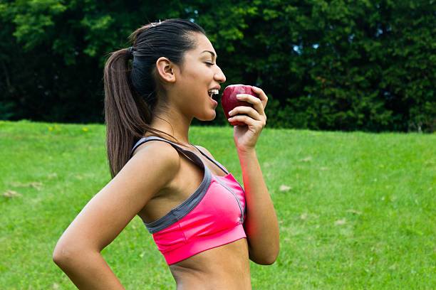 istock Fit young woman eating an apple 186705183