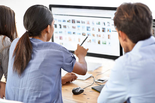 I choose you! Three editors looking through images on a computer photo editing screen stock pictures, royalty-free photos & images
