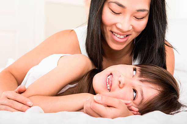 Mother and daughter laying in bed