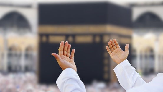Islam Iconic Mosque, Al Haram Mecca Saudi Arabia. Muslim Praying Hands in front of The Holy Kaaba which is the center of Islam inside Masjid Al Haram Mecca.