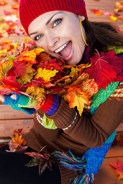 istock Smiling woman holding autumn leaves 186710504
