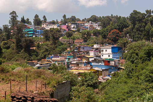 Ooty, Tamil Nadu, India - October 6 2023: View of houses clustered on the slopes of a hill in a village around he town of Ooty.