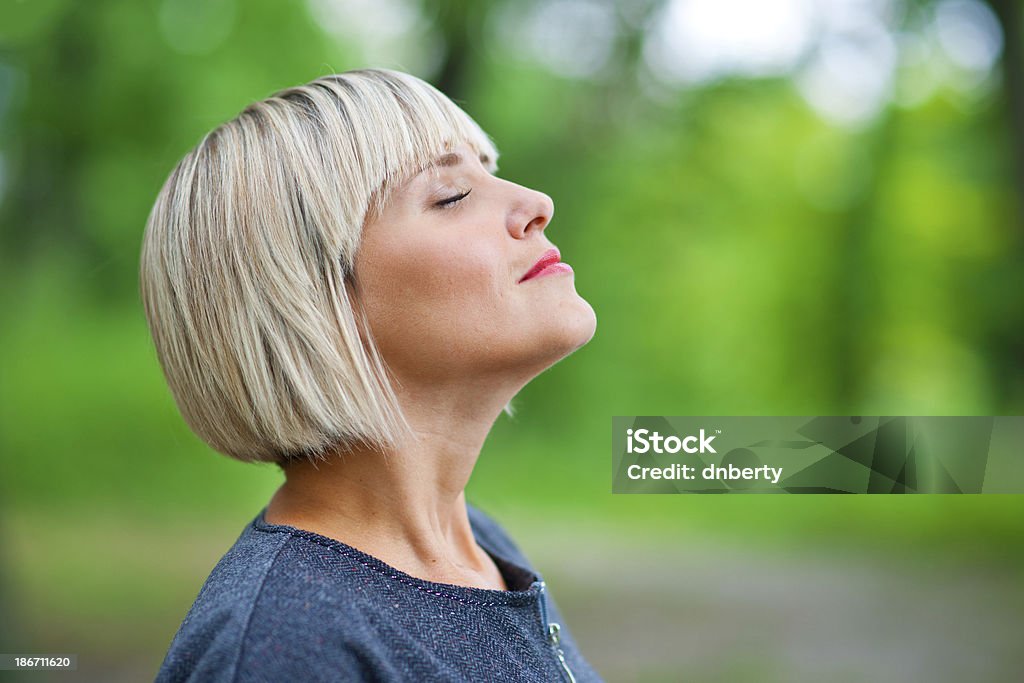 attractive woman breathing and relaxing attractive blond woman breathing and relaxing in nature Breathing Exercise Stock Photo