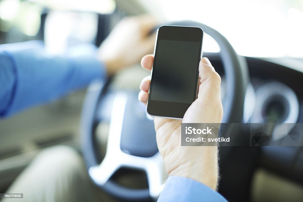 Using smartphone a car. Closeup of male hand holding smartphone in a car. 30-39 Years Stock Photo