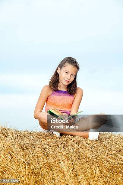 Photo libre de droit de Petite Fille Assise Sur Le Foin Lecture banque d'images et plus d'images libres de droit de 10-11 ans - 10-11 ans, Activité de loisirs, Apprentissage