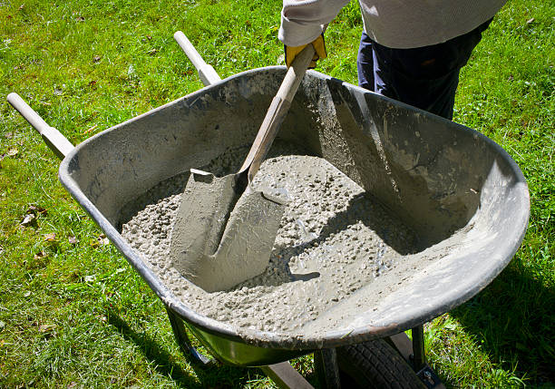 Mixing Cement by Hand in a Wheelbarrow. stock photo