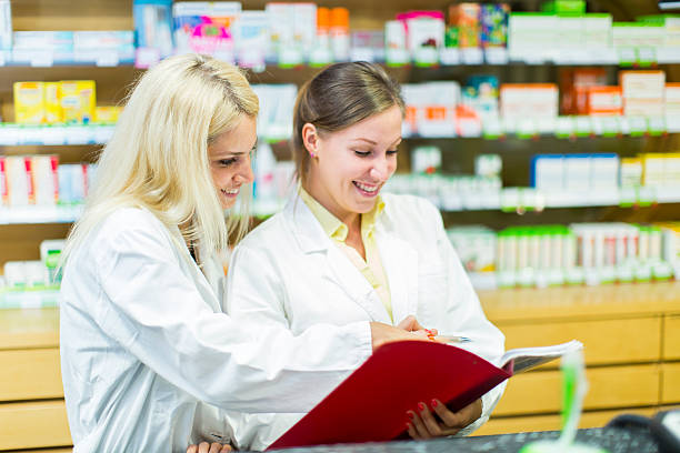 istock Cute female pharmacists at pharmacy checking supplies 186714412