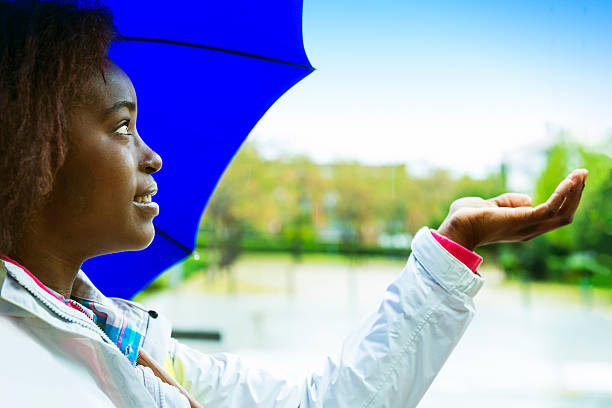 godersi una giornata di pioggia in città - candid women african descent umbrella foto e immagini stock