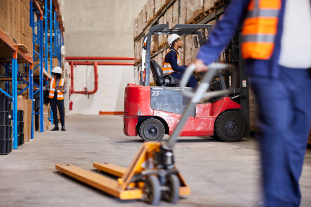 istock Workers tracking inventory and moving pallets in a distribution warehouse 1867146126
