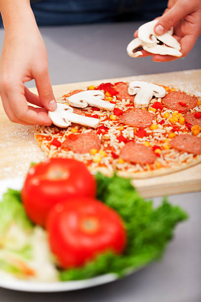 Young woman preparing homemade pizza - just before baking it