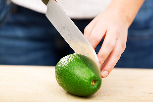 istock Young woman peeling avocado 186716611