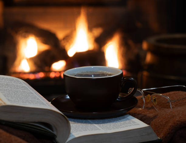 istock Cup of coffee with burning fireplace in background 1867185817