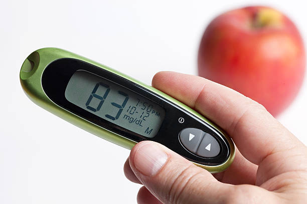 Glucometer with Normal Blood Glucose Level and Apple stock photo