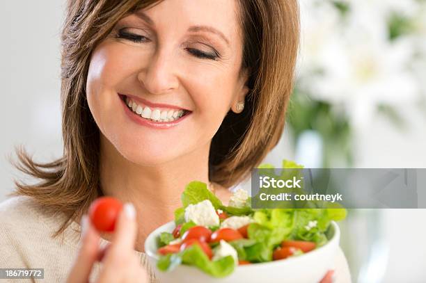 Maduro Feliz Mujer Sosteniendo Una Ensalada Foto de stock y más banco de imágenes de Adulto - Adulto, Adulto maduro, Agarrar