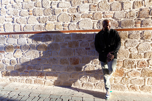 Portrait of afro men leaning against the wall