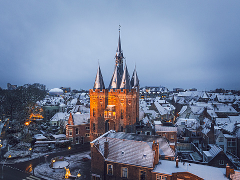 Zwolle Sassenpoort old gate during a cold winter morning with snow on the rooftops in the downtown district seen from above. The Sassenpoort was constructed in the 14th century, specifically between 1406 and 1409, and served as one of the main entrances to the fortified city of Zwolle. It was built as part of the city's defensive walls and was primarily used to control access into the city, as well as to protect its inhabitants from potential threats.

The gate's name, 